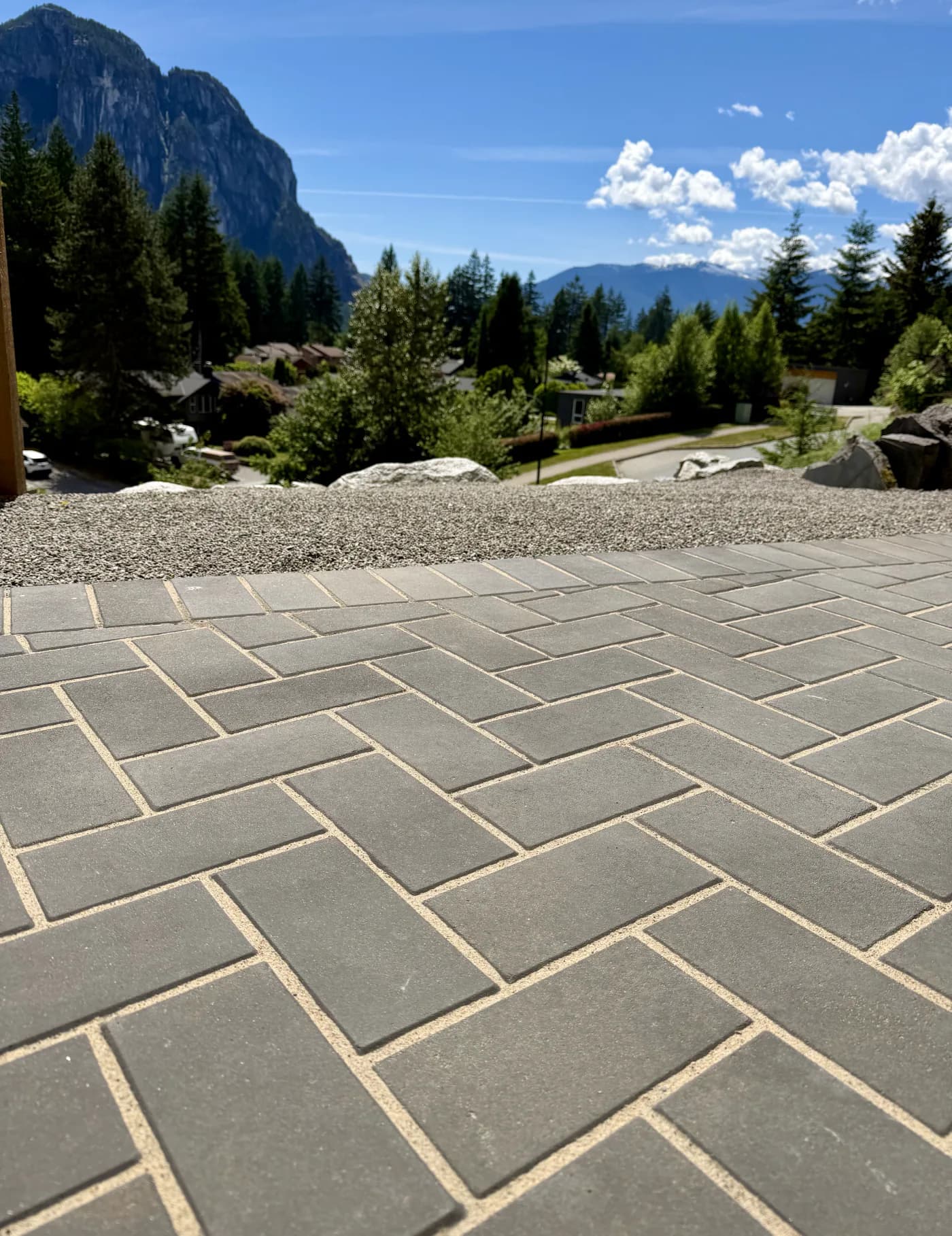 Herringbone paver driveway with freshly filled sand joints, looking out over Squamish to the mountains
